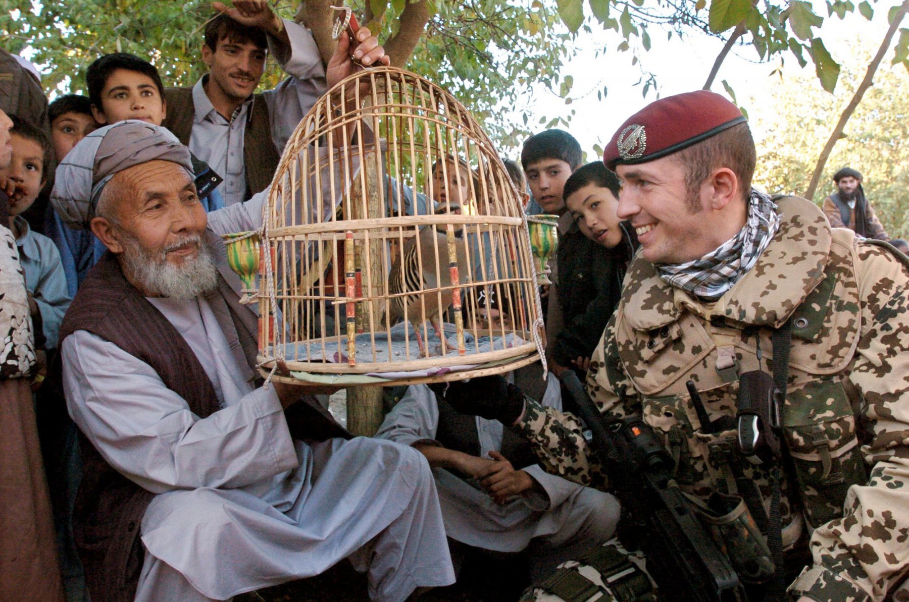 Einen Vogel preist dieser Vogelhändler auf einem Markt in der afghanischen Provinzstadt Kundus einem Bundeswehrsoldaten an.Foto: Boris Roessler/dpa