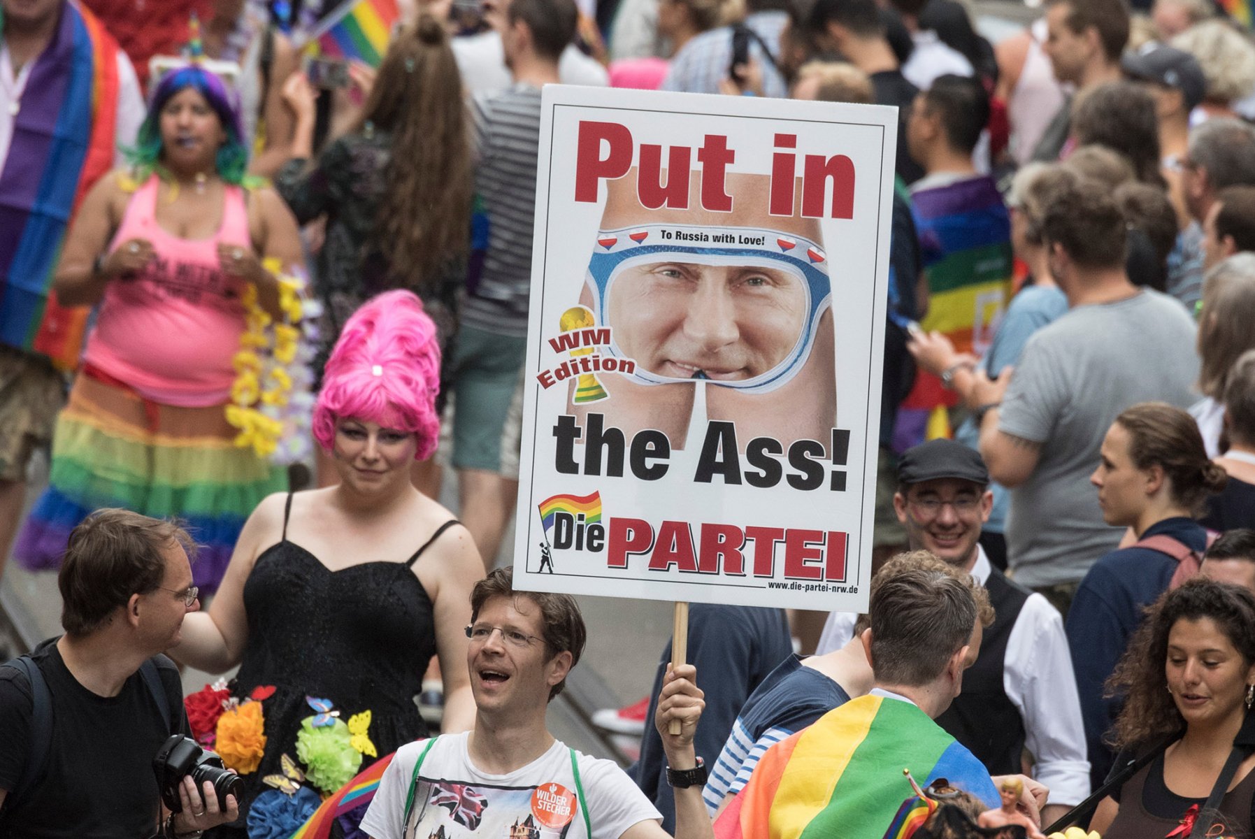 Teilnehmer der Parade zum Christopher-Street-Day (CSD) ziehen durch die Innenstadt. Dabei hält ein Teilnehmer ein Plakat mit dem Bild des russischen Präsidenten Putin in die Höhe. Foto: Boris Roessler/dpa